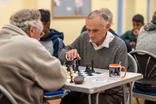 A player reaching to make a move during a club game